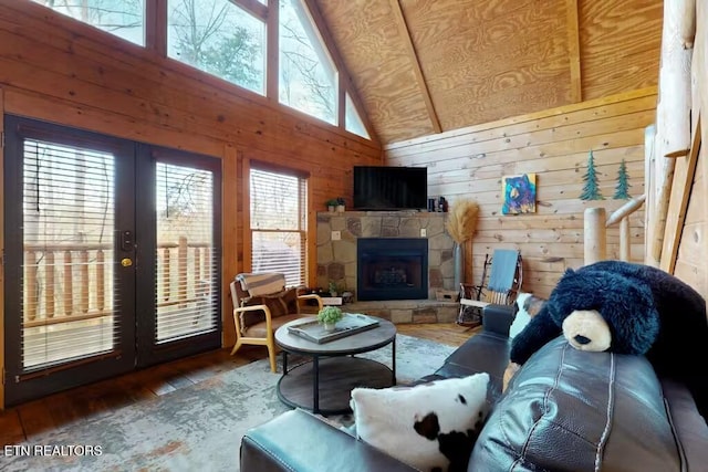 living room with hardwood / wood-style flooring, high vaulted ceiling, plenty of natural light, and wooden walls