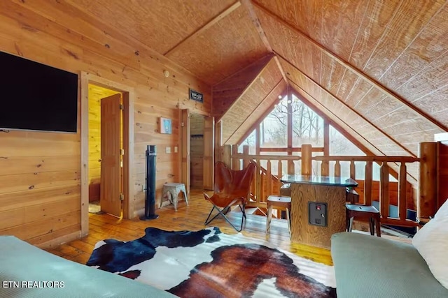 living room featuring light wood-type flooring, vaulted ceiling, wood walls, and wood ceiling