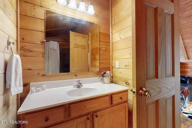 bathroom featuring vanity, toilet, and wooden walls