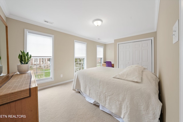 bedroom featuring ornamental molding, visible vents, a closet, and light carpet