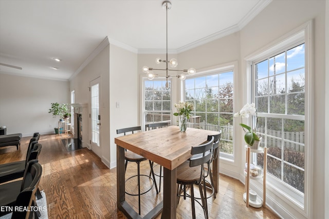 dining room with baseboards, light wood-style floors, and ornamental molding