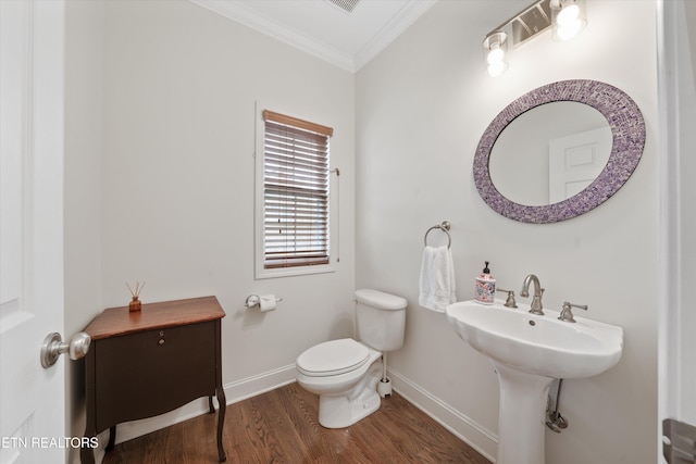 half bathroom featuring toilet, crown molding, baseboards, and wood finished floors