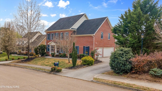 view of front of house with a garage, brick siding, concrete driveway, and a front yard