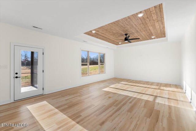 spare room featuring light hardwood / wood-style floors, a raised ceiling, wooden ceiling, and a wealth of natural light