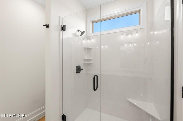 bathroom featuring a shower with door