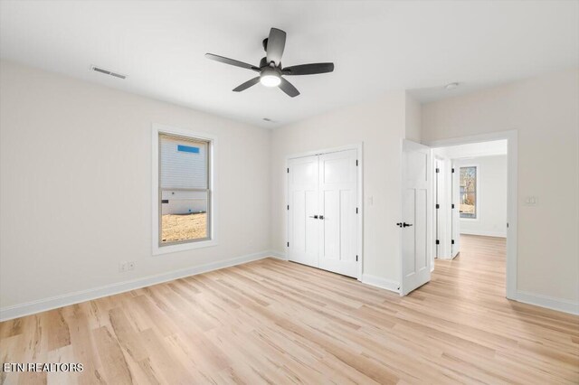 unfurnished bedroom with ceiling fan, a closet, and light hardwood / wood-style floors