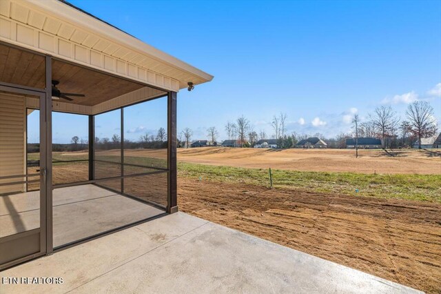 view of patio / terrace featuring ceiling fan and a rural view