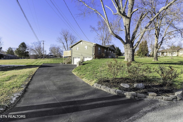 view of side of home featuring a garage and a lawn