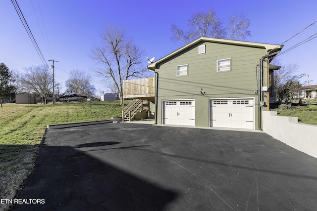 view of side of property with a garage and a yard