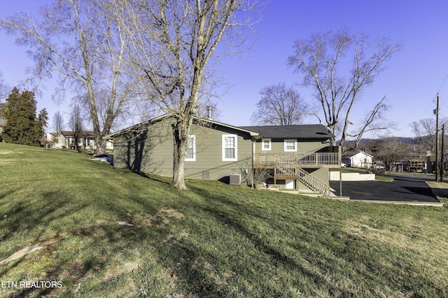 back of house with a lawn and a wooden deck