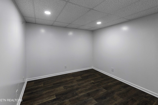 unfurnished room featuring a paneled ceiling and dark hardwood / wood-style floors