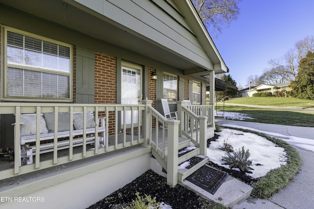 property entrance with a yard and covered porch