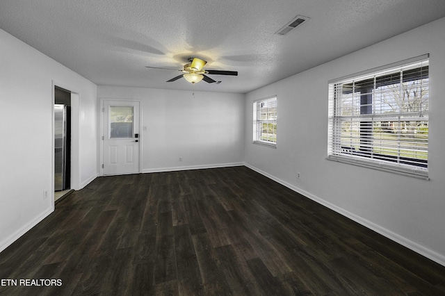 unfurnished room with ceiling fan, dark hardwood / wood-style floors, and a textured ceiling