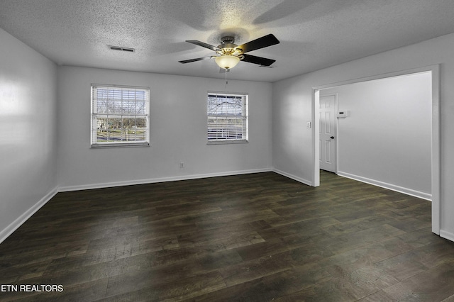 empty room with ceiling fan, dark wood-type flooring, and a textured ceiling