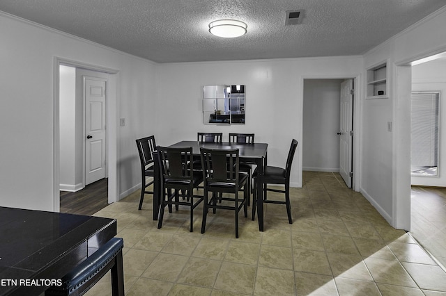 dining room with a textured ceiling and tile patterned flooring