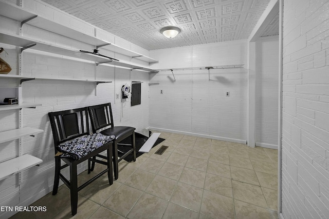 exercise room featuring light tile patterned floors and electric panel