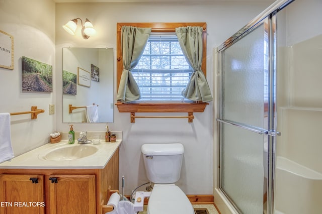 bathroom with vanity, an enclosed shower, and toilet