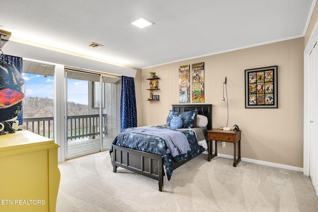 carpeted bedroom featuring access to exterior, a textured ceiling, and ornamental molding