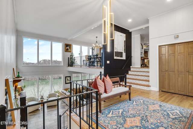 living room with light hardwood / wood-style floors, a towering ceiling, and a notable chandelier