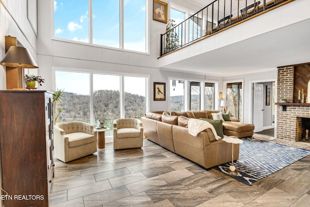 living room with a brick fireplace and a high ceiling