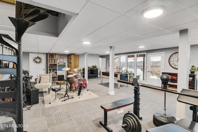 workout area featuring light colored carpet and a paneled ceiling