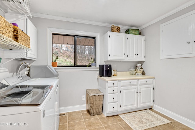 laundry area with light tile patterned floors, independent washer and dryer, crown molding, and cabinets