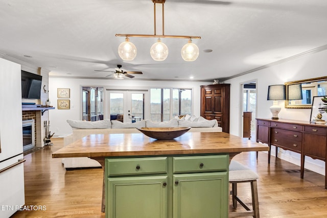 kitchen with french doors, wooden counters, green cabinets, and a center island