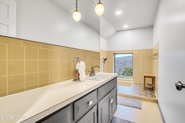 bathroom featuring tile patterned floors, vanity, a tile shower, and lofted ceiling