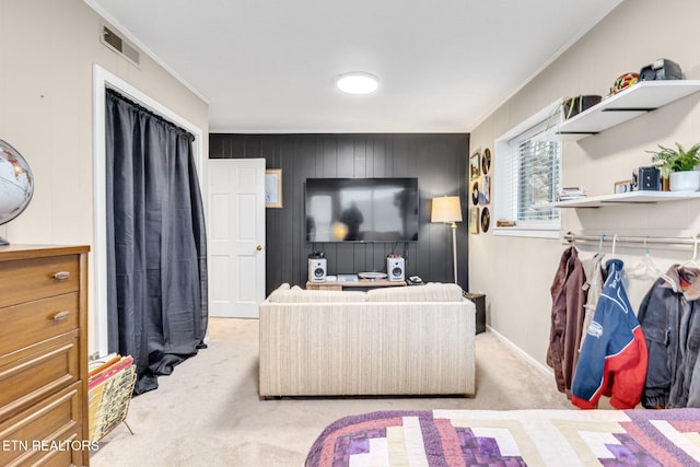 carpeted bedroom featuring a closet, wood walls, and crown molding