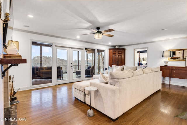 living room with ceiling fan, french doors, ornamental molding, and hardwood / wood-style flooring