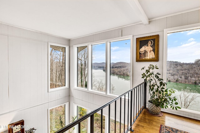 sunroom / solarium with beam ceiling and a water view