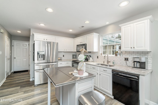 kitchen with sink, a center island, white cabinets, and black appliances