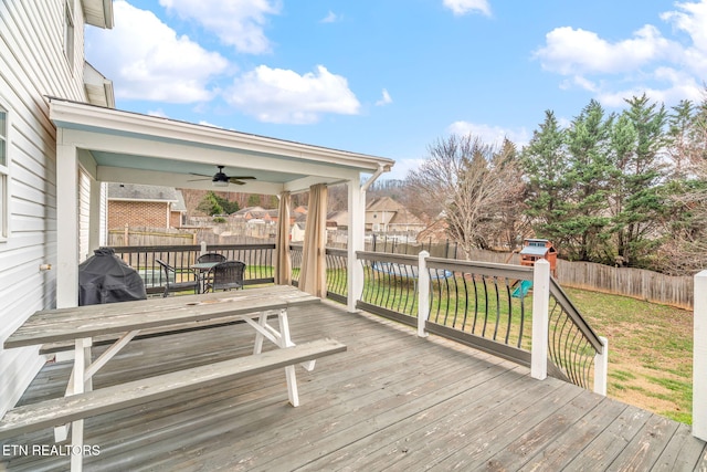 deck with a lawn, ceiling fan, and a playground