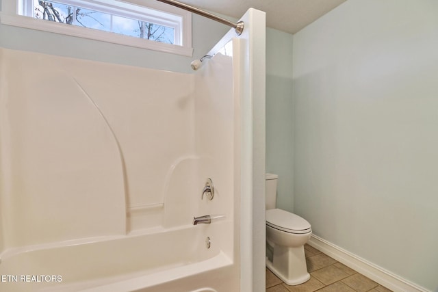 bathroom featuring tile patterned flooring, bathtub / shower combination, and toilet