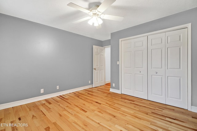 unfurnished bedroom with ceiling fan, light wood-type flooring, and a closet