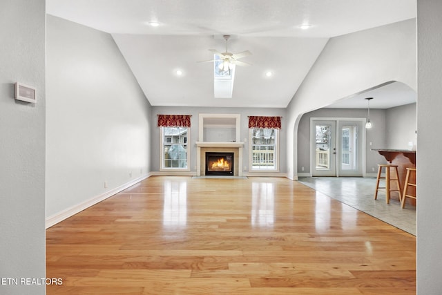 unfurnished living room featuring ceiling fan, light hardwood / wood-style floors, and a wealth of natural light