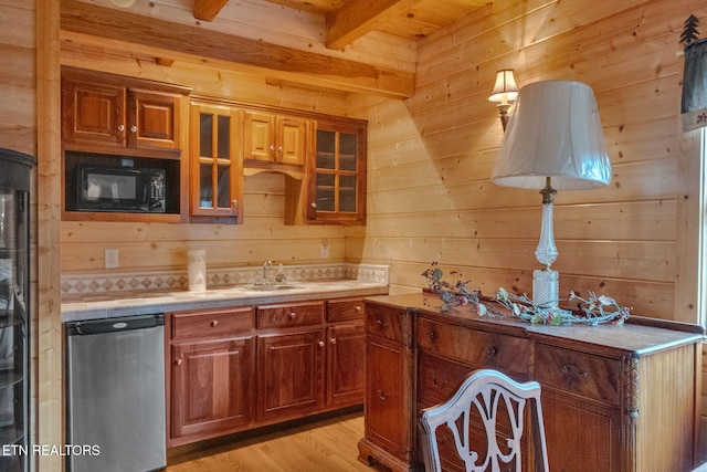 kitchen with beam ceiling, light wood-type flooring, wooden walls, and sink