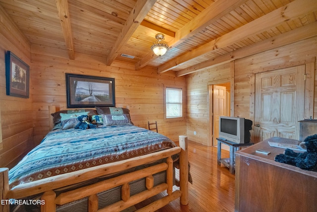 bedroom featuring beamed ceiling, light wood-type flooring, wood ceiling, and wooden walls