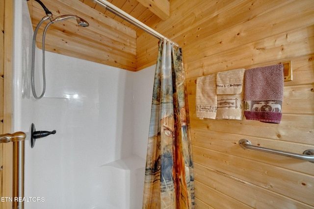 bathroom with a shower with shower curtain, wooden ceiling, and wood walls