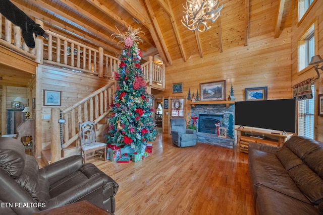 living room with beamed ceiling, high vaulted ceiling, wooden ceiling, and wood walls