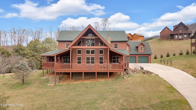 cabin with a wooden deck and a front lawn