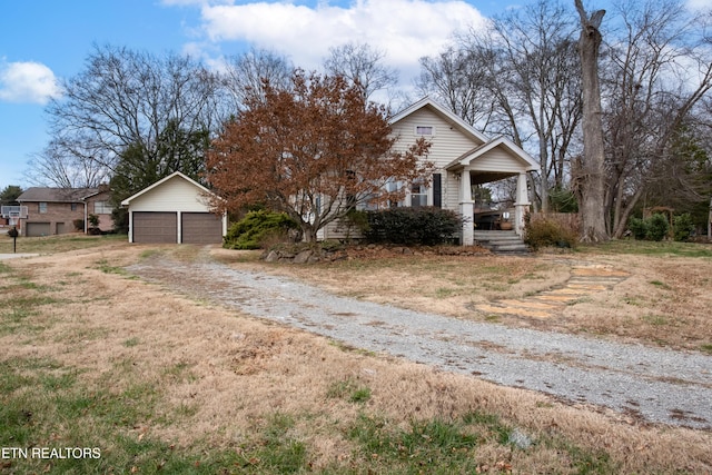 view of front of house with an outbuilding, a garage, and covered porch