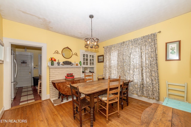 dining room with light hardwood / wood-style flooring and a notable chandelier