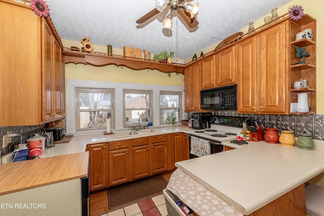 kitchen with kitchen peninsula, light tile patterned floors, electric range, and backsplash