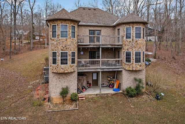 rear view of property featuring a patio area and a balcony