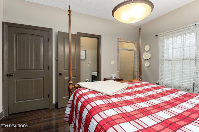 bedroom featuring dark hardwood / wood-style flooring and a textured ceiling