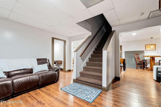 living room with a paneled ceiling and wood-type flooring