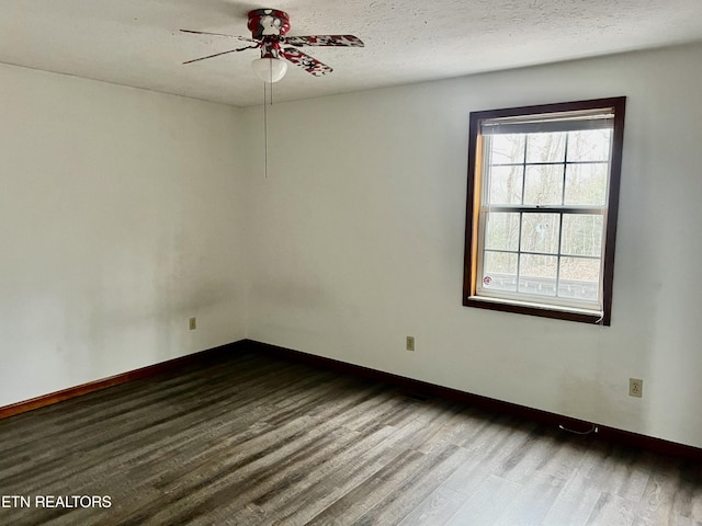 empty room with a textured ceiling, ceiling fan, and dark wood-type flooring