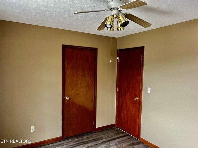 unfurnished bedroom with a textured ceiling, a closet, dark hardwood / wood-style floors, and ceiling fan