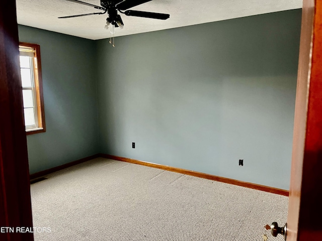 spare room featuring carpet flooring, ceiling fan, and a textured ceiling